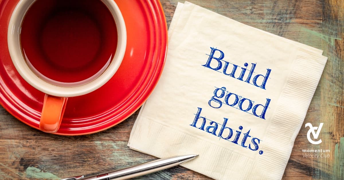 A cup of tea. Next to it is a paper napkin with the words 'build good habits' on it.