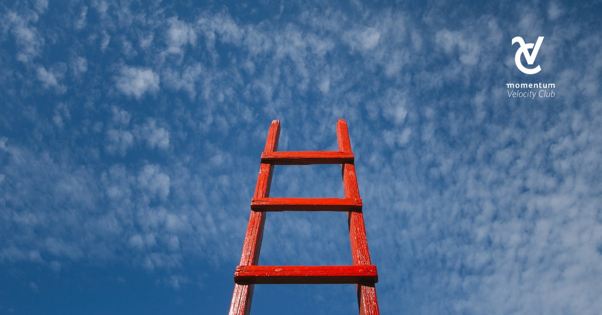A red step ladder reaching up to a blue sky.