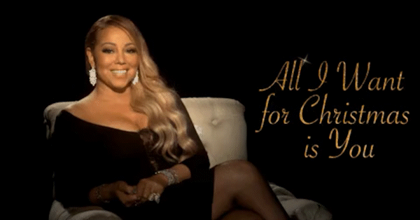 Mariah Carey dressed in evening wear, seated on a chair.