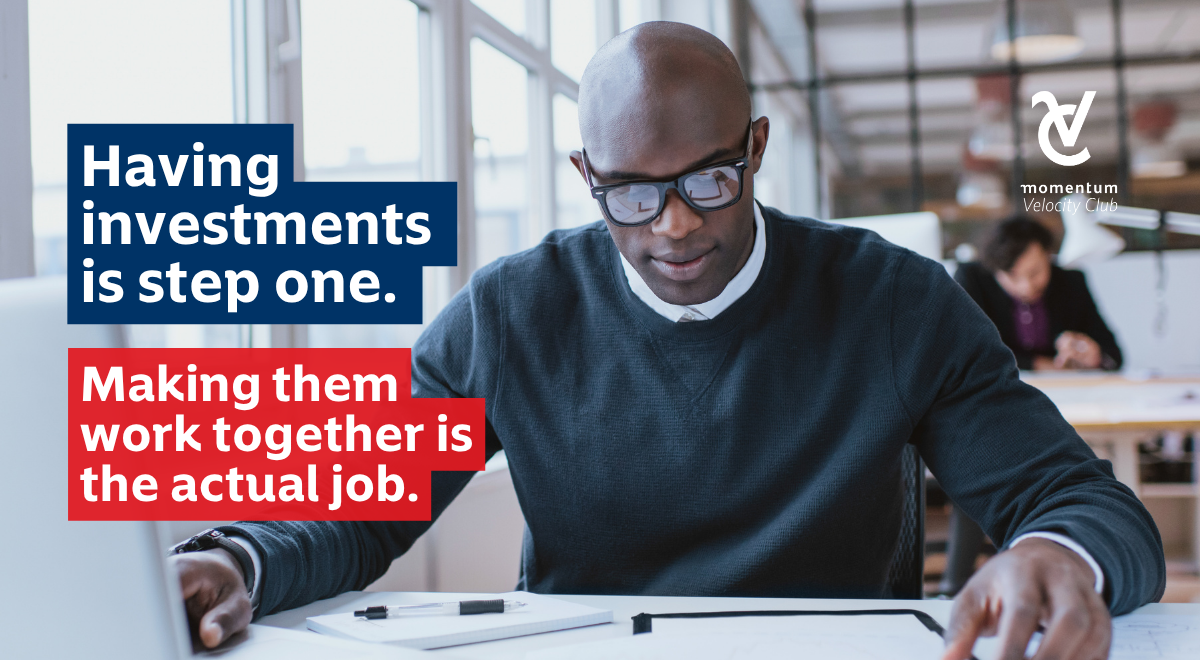 A focused man in glasses at a desk reviewing his investments to ensure they work together effectively.