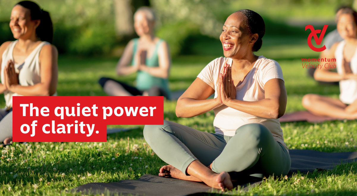 A confident woman in an outdoor group yoga class, building focus and calm ahead of the new year.