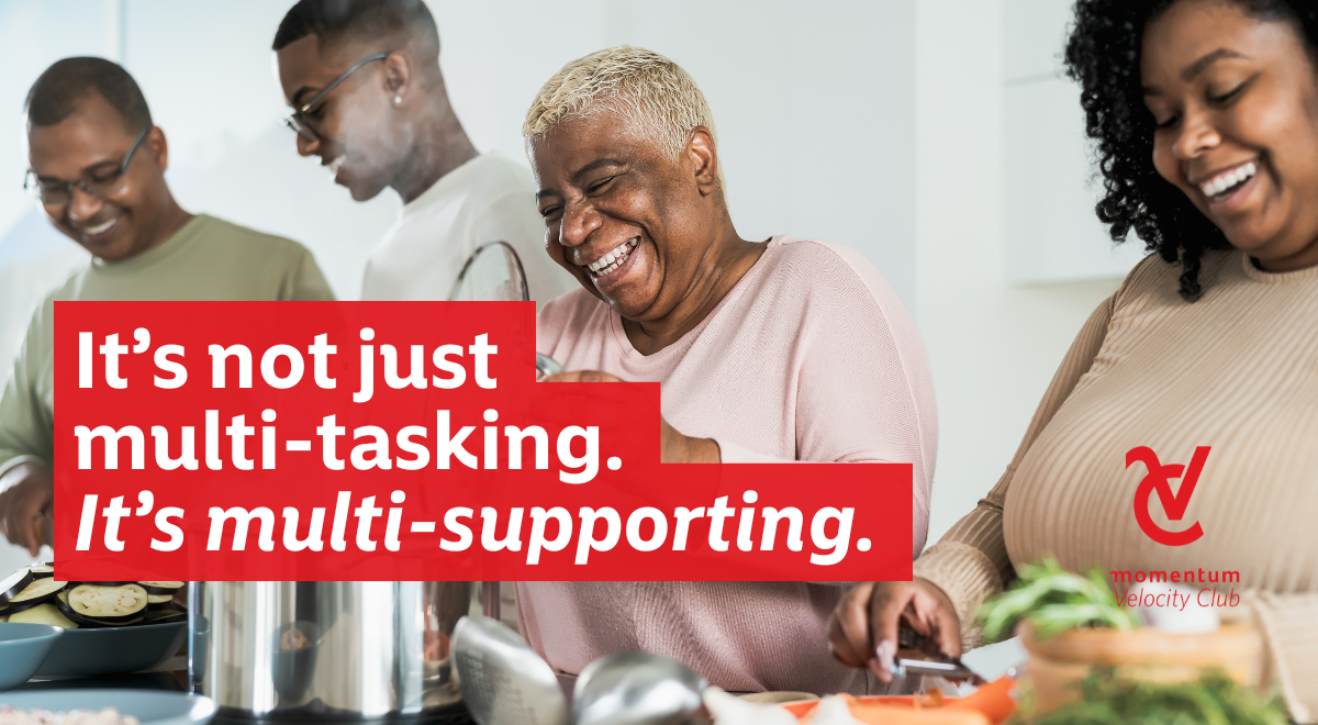 A family matriarch spending quality time with her older children who are helping her make a family meal in the kitchen. 