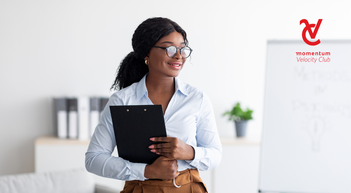 An established African female professional wearing glasses and holding a file at the office.